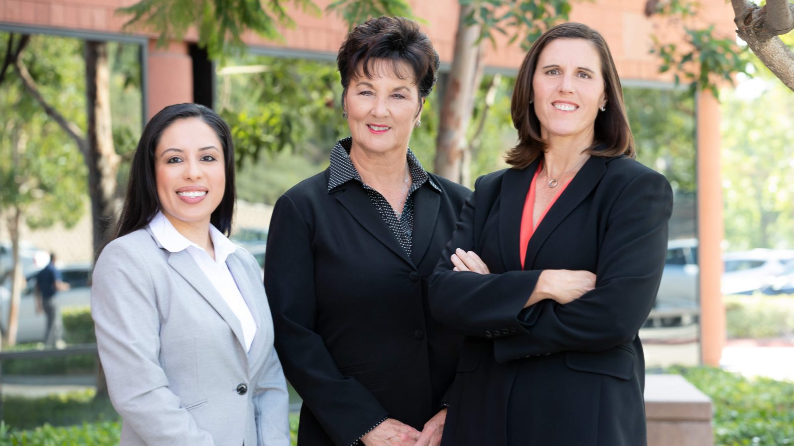 Three female lawyers in front of a building.