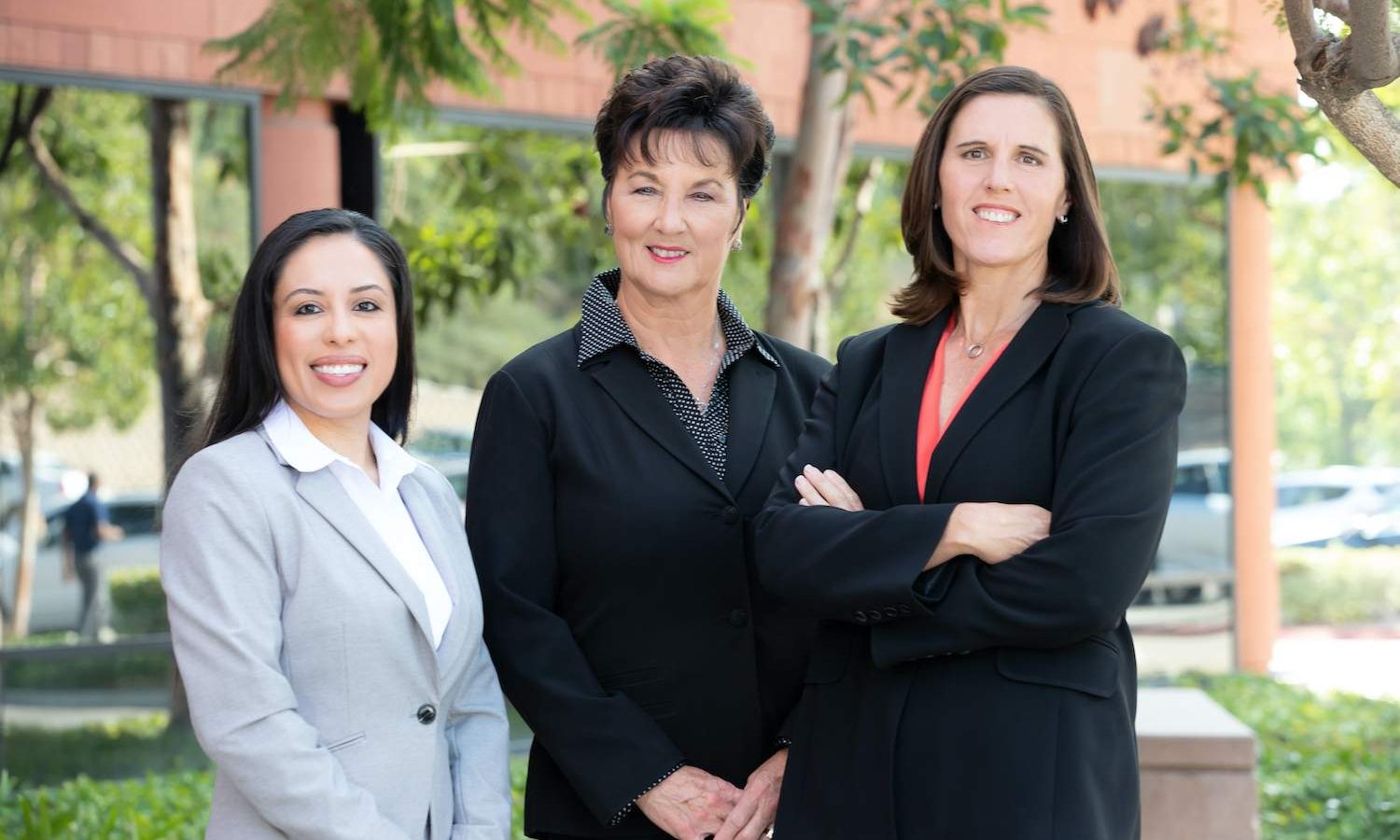 Three female lawyers in front of a building.
